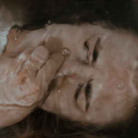 woman holding nose under water